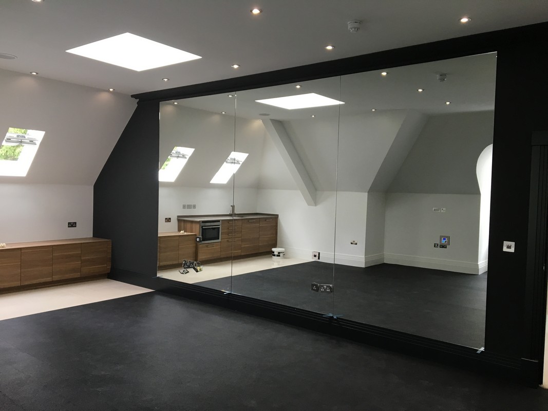 Frameless glass wall dividing loft conversion in  Bromley by Bow